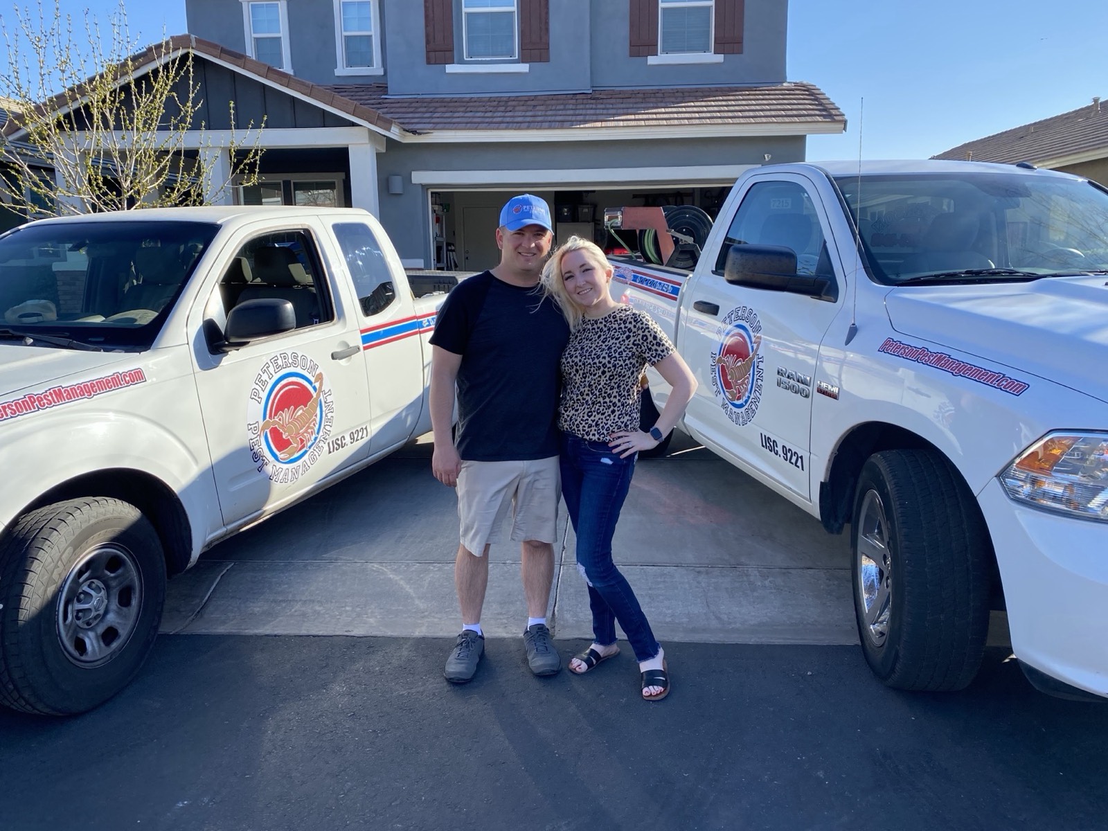 Brandon and Cheyenne Peterson in front of the Peterson Pest Management trucks
