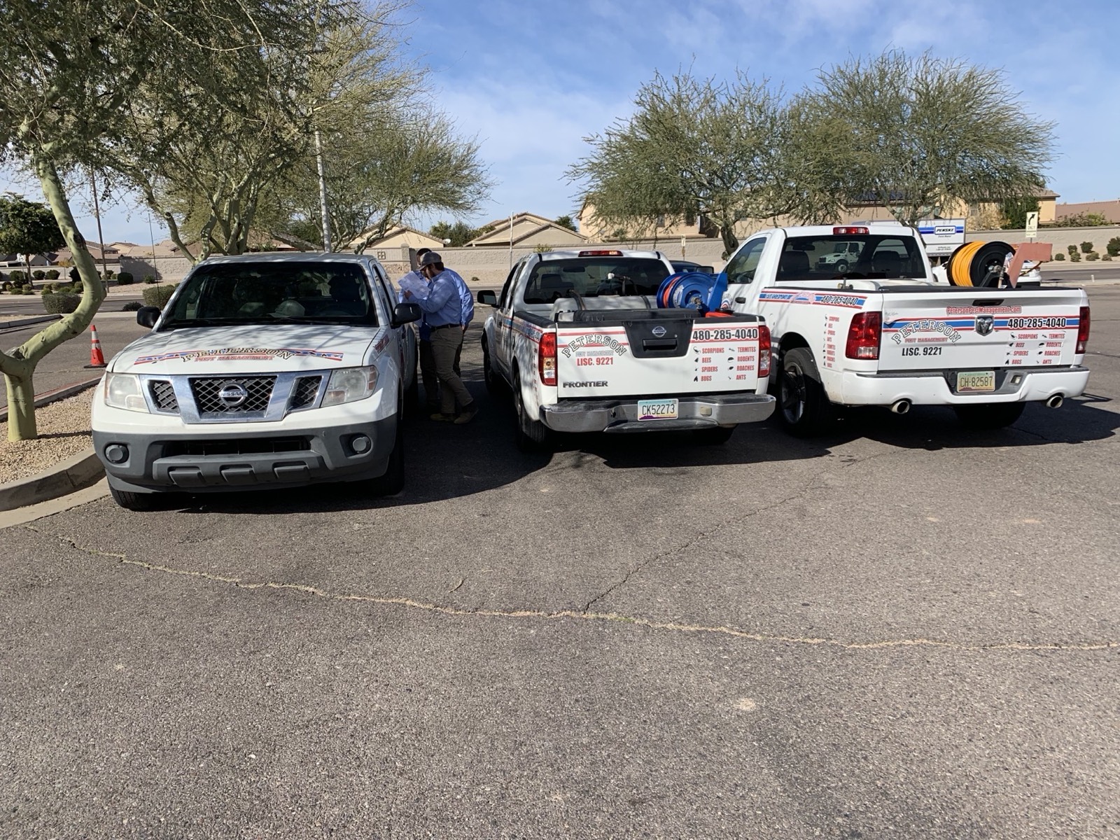 Three Peterson Pest Management trucks lined up in an East Valley parking lot