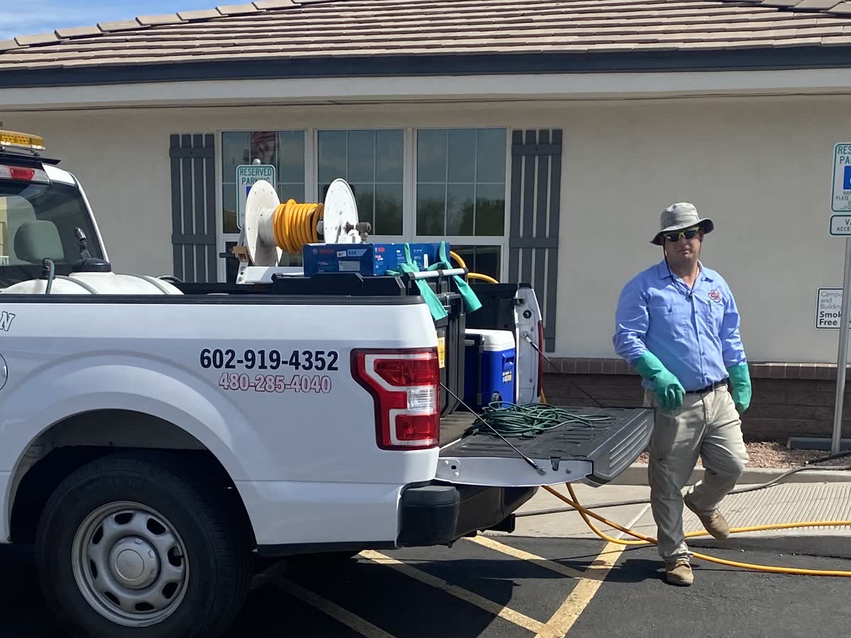 Peterson Pest Management technician pulling the hose reel off the truck at a Mesa, Arizona service call